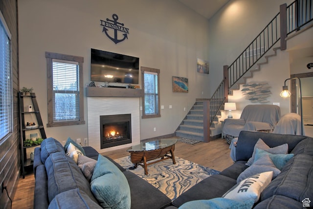 1400 N Cisco Cir, Garden City, UT 84028 - living room with wood finished floors, stairway, a tiled fireplace, and a high ceiling