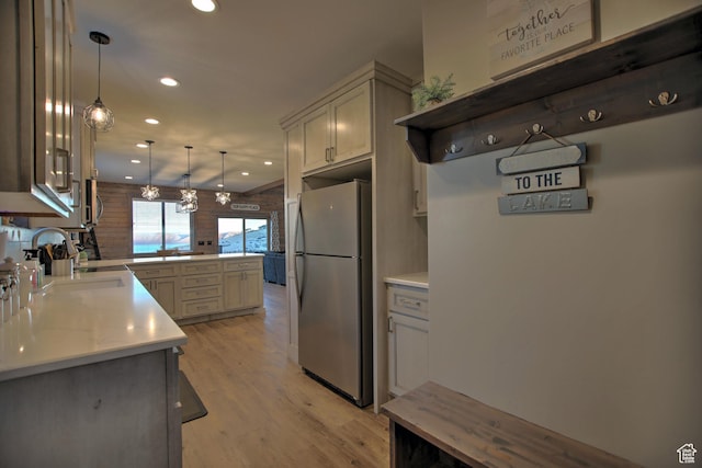 1400 N Cisco Cir, Garden City, UT 84028 - kitchen with freestanding refrigerator, a peninsula, a sink, light countertops, and light wood-style floors