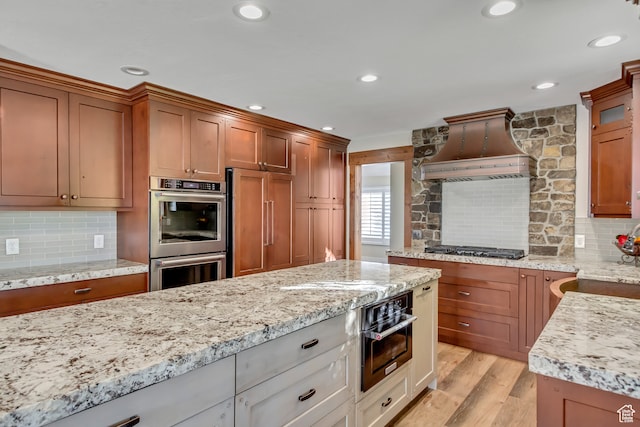 158 E Shepard Ln, Kaysville, UT 84037 - kitchen featuring light stone countertops, custom range hood, stainless steel appliances, light hardwood / wood-style floors, and white cabinetry