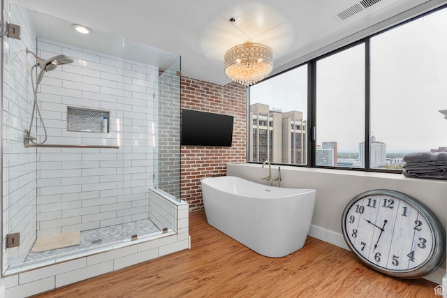 44 W Broadway S Unit 1205S, Salt Lake City, UT 84101 - bathroom with a chandelier, shower with separate bathtub, and wood-type flooring
