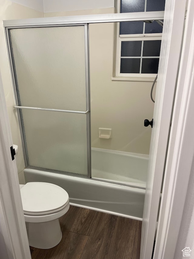 bathroom with toilet, combined bath / shower with glass door, and hardwood / wood-style floors