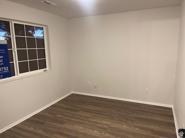 empty room with dark hardwood / wood-style flooring