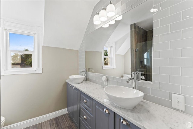 673 E 7th Ave, Salt Lake City, UT 84103 - full bathroom featuring double vanity, tasteful backsplash, lofted ceiling, baseboards, and wood finished floors
