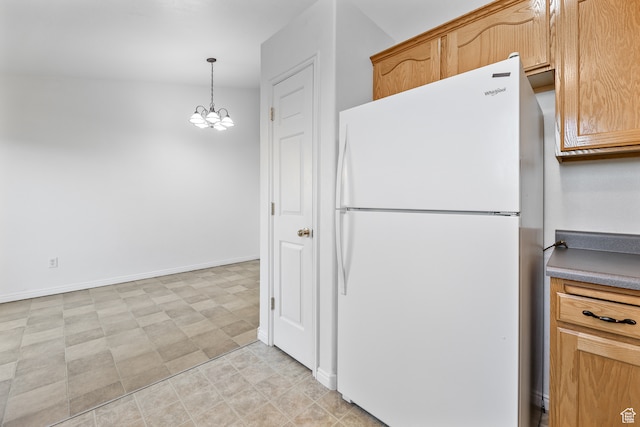 kitchen featuring a chandelier, decorative light fixtures, and white fridge