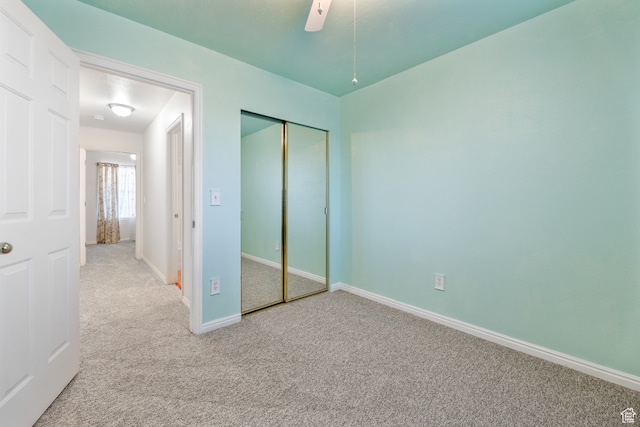unfurnished bedroom with light colored carpet, ceiling fan, and a closet