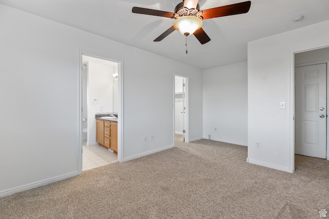 unfurnished bedroom featuring light carpet, ceiling fan, and ensuite bath