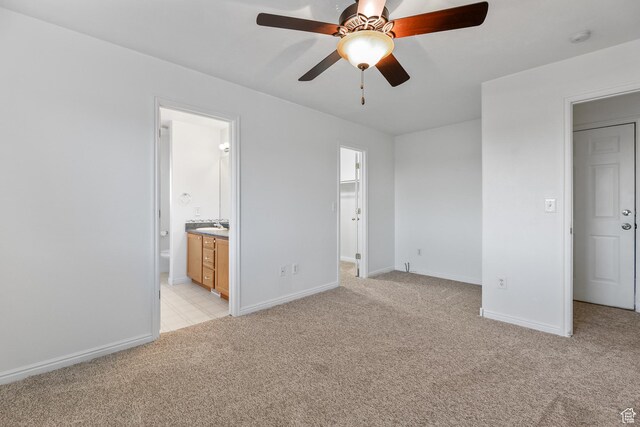 948 W 540th St S, Tooele, UT 84074 - unfurnished bedroom with light colored carpet, baseboards, a sink, a walk in closet, and connected bathroom
