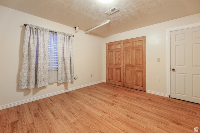 948 W 540th St S, Tooele, UT 84074 - unfurnished bedroom featuring light wood-style floors, baseboards, a textured ceiling, and a closet