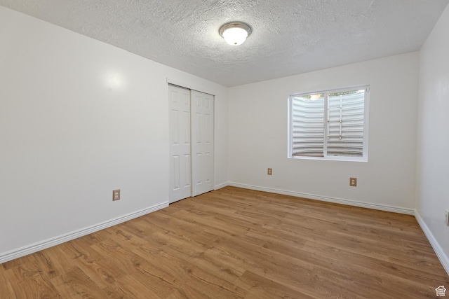948 W 540th St S, Tooele, UT 84074 - unfurnished bedroom featuring wood finished floors, baseboards, a textured ceiling, and a closet