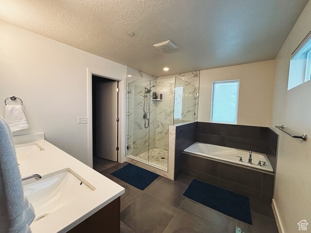 bathroom featuring vanity, a textured ceiling, tile patterned floors, and plus walk in shower