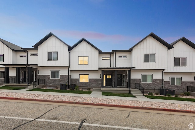 multi unit property with board and batten siding, central AC, and stone siding