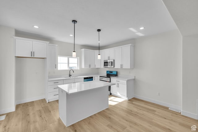 7901 S 2700 E Unit 203, South Weber, UT 84405 - kitchen with white cabinets, light countertops, a sink, light wood-style flooring, and appliances with stainless steel finishes