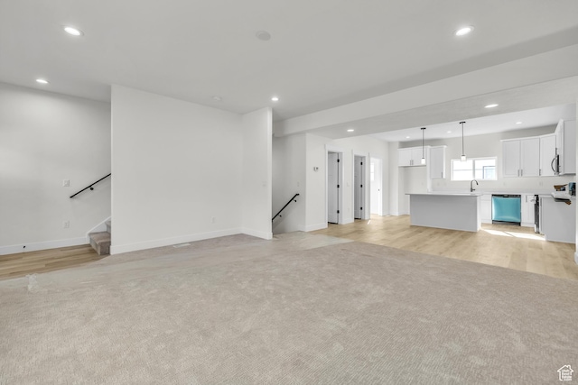 7901 S 2700 E Unit 203, South Weber, UT 84405 - unfurnished living room featuring baseboards, a sink, recessed lighting, and light colored carpet