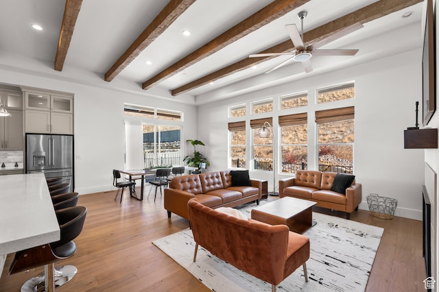 living room with beamed ceiling, light hardwood / wood-style floors, and ceiling fan