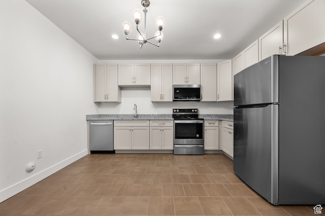kitchen featuring stainless steel appliances, white cabinetry, sink, a notable chandelier, and pendant lighting