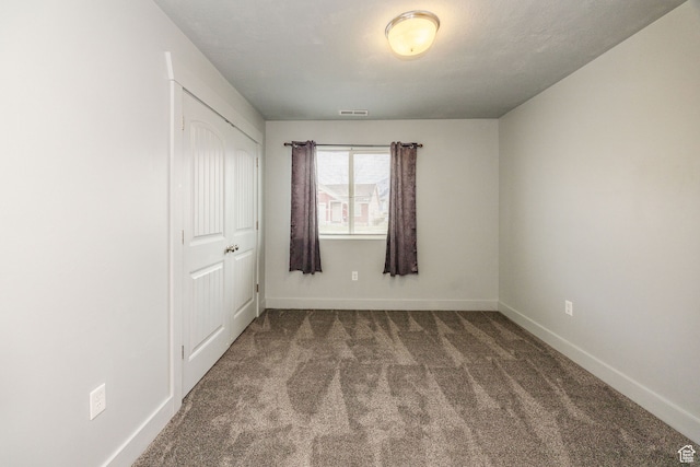 unfurnished bedroom featuring carpet flooring and a closet