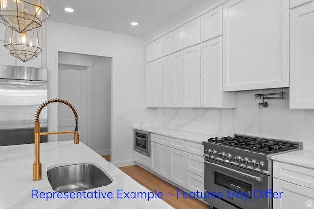 3689 S Riverstone Rd, Mapleton, UT 84664 - kitchen featuring premium appliances, a sink, decorative backsplash, white cabinets, and light stone counters