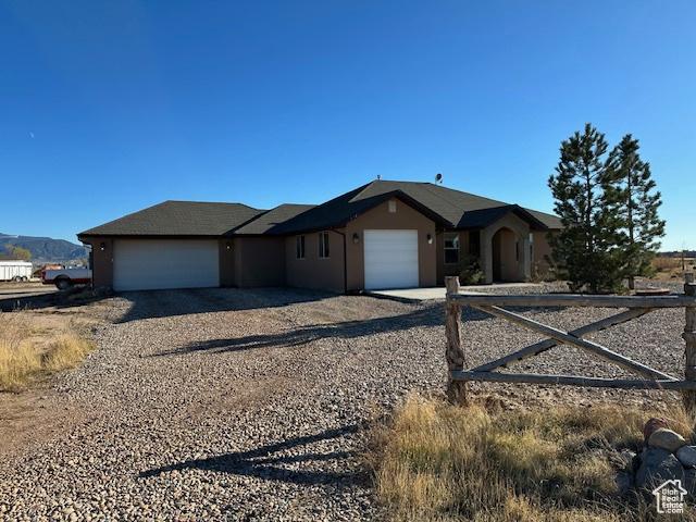 3741 W 5200 N, Cedar City, UT 84721 - ranch-style home with dirt driveway, an attached garage, and stucco siding