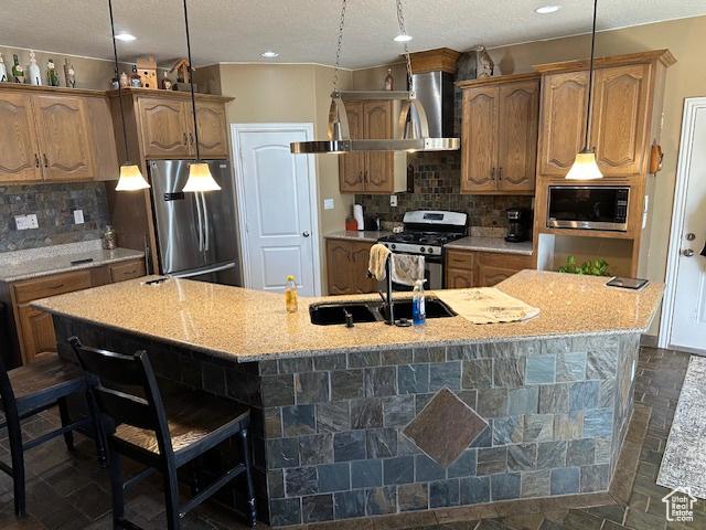 3741 W 5200 N, Cedar City, UT 84721 - kitchen featuring appliances with stainless steel finishes, a sink, a spacious island, a kitchen bar, and decorative backsplash
