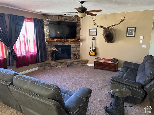 3741 W 5200 N, Cedar City, UT 84721 - carpeted living room featuring ceiling fan, a stone fireplace, baseboards, and a textured ceiling