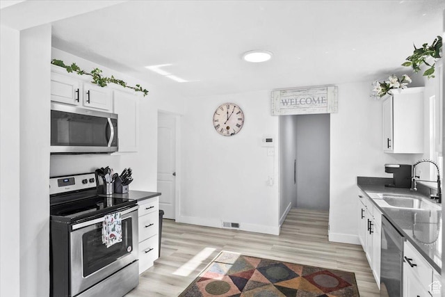 2034 S Laine Ave E, Ogden, UT 84401 - kitchen featuring appliances with stainless steel finishes, a sink, white cabinetry, and baseboards