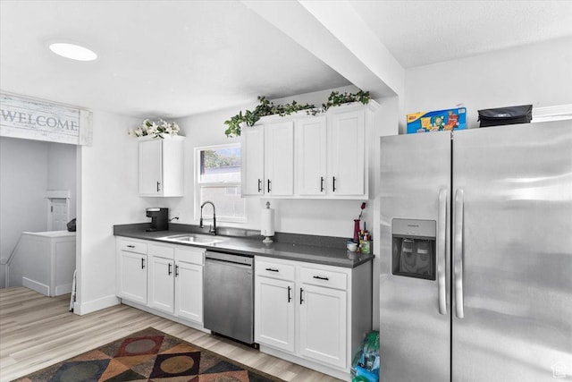 2034 S Laine Ave E, Ogden, UT 84401 - kitchen with stainless steel appliances, a sink, dark countertops, light wood-type flooring, and white cabinetry