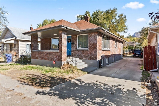 2034 S Laine Ave E, Ogden, UT 84401 - view of front of home with brick siding, a chimney, and concrete driveway