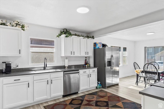 2034 S Laine Ave E, Ogden, UT 84401 - kitchen with appliances with stainless steel finishes, a sink, dark countertops, and white cabinetry