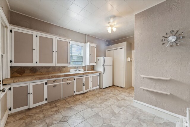 7865 S Main St, Midvale, UT 84047 - kitchen with ceiling fan, sink, light tile patterned flooring, white fridge, and white cabinets