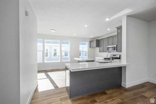 3475 S Perthshire Dr Unit 30, South Salt Lake, UT 84115 - kitchen with stainless steel microwave, gray cabinets, range, light countertops, and baseboards