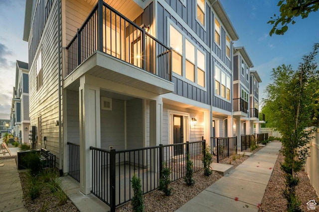 3475 S Perthshire Dr Unit 30, South Salt Lake, UT 84115 - view of side of property featuring board and batten siding, a balcony, and covered porch