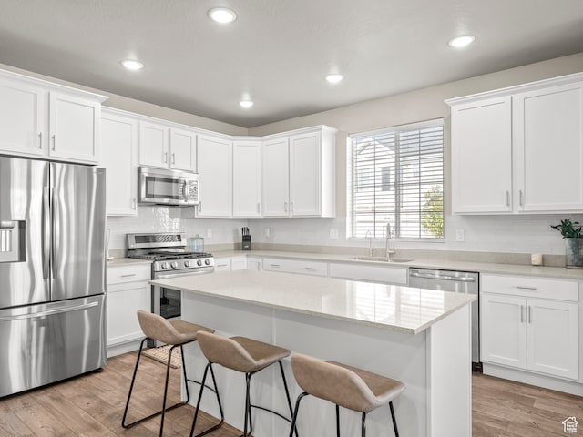 2424 N Lazy J Ln, Lehi, UT 84043 - kitchen featuring sink, white cabinets, appliances with stainless steel finishes, a kitchen island, and light wood-type flooring