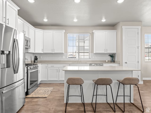 2424 N Lazy J Ln, Lehi, UT 84043 - kitchen with white cabinetry, sink, stainless steel appliances, light hardwood / wood-style floors, and a kitchen island