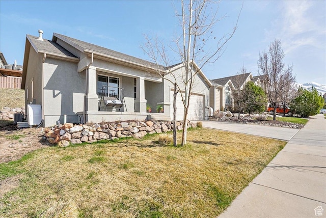 single story home featuring central AC, an attached garage, covered porch, stucco siding, and driveway