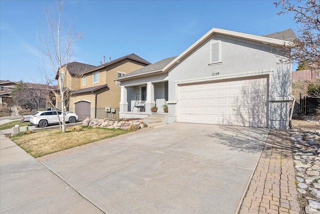 view of front of property with an attached garage, driveway, and stucco siding