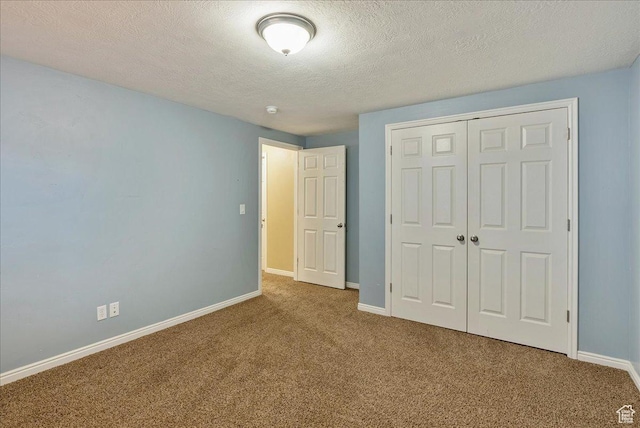 unfurnished bedroom with a closet, baseboards, carpet flooring, and a textured ceiling