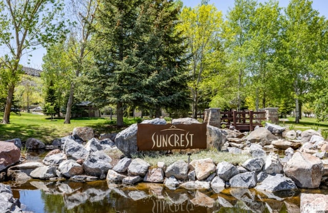 community / neighborhood sign featuring a yard