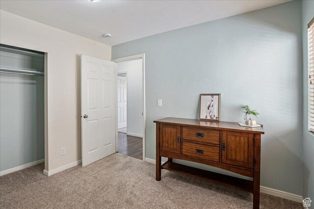 carpeted bedroom with a closet and baseboards