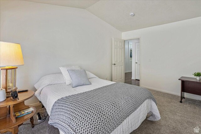 carpeted bedroom featuring baseboards and vaulted ceiling
