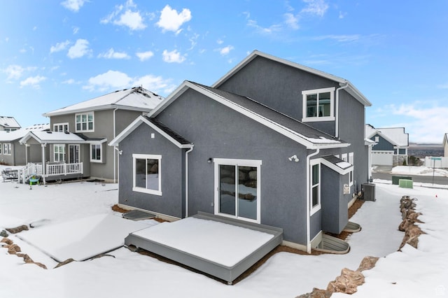 snow covered rear of property with central air condition unit and a porch