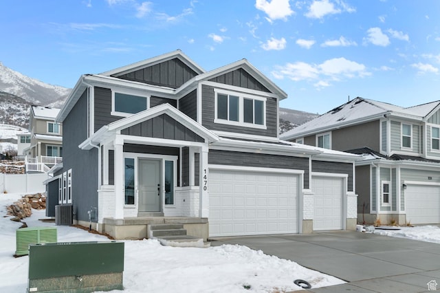 view of front facade featuring a garage, central AC, and a mountain view