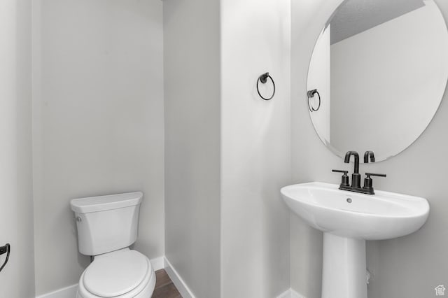 bathroom featuring hardwood / wood-style flooring and toilet