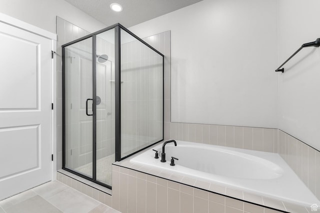 bathroom featuring shower with separate bathtub, tile patterned floors, and a textured ceiling