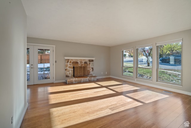 151 S Bernice Way, North Salt Lake, UT 84054 - unfurnished living room with a fireplace, light hardwood / wood-style floors, french doors, and a healthy amount of sunlight