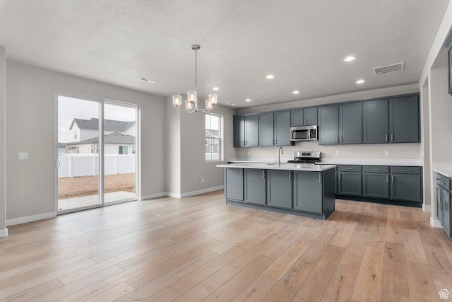 1849 S 2475 W, West Haven, UT 84401 - kitchen featuring appliances with stainless steel finishes, a kitchen island with sink, sink, decorative light fixtures, and a chandelier