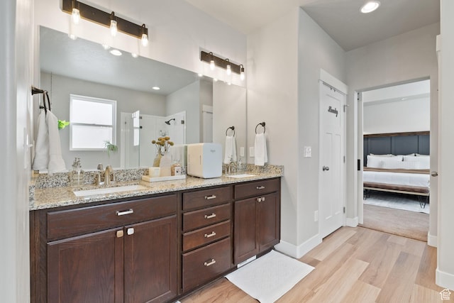 6443 W Early Bird Dr, South Jordan, UT 84009 - full bathroom with ensuite bathroom, wood finished floors, double vanity, a walk in shower, and baseboards