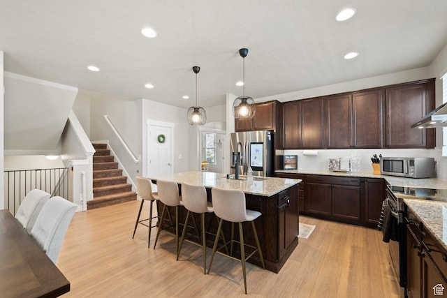 6443 W Early Bird Dr, South Jordan, UT 84009 - kitchen featuring stainless steel appliances, light wood finished floors, an island with sink, dark brown cabinets, and recessed lighting