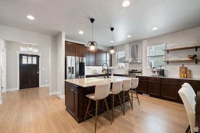 6443 W Early Bird Dr, South Jordan, UT 84009 - kitchen featuring appliances with stainless steel finishes, wall chimney exhaust hood, a sink, backsplash, and dark brown cabinets