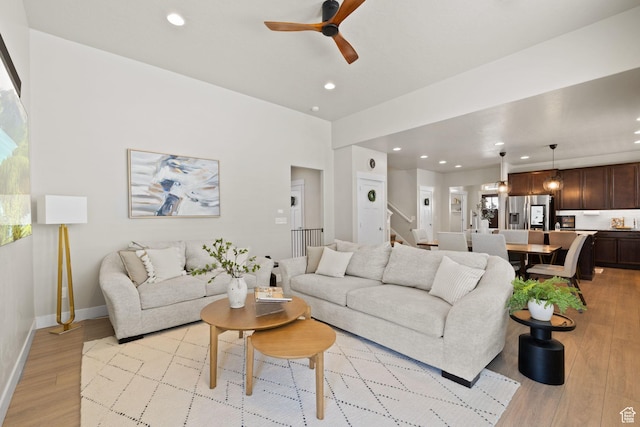 6443 W Early Bird Dr, South Jordan, UT 84009 - living area with light wood-style floors, ceiling fan, recessed lighting, baseboards, and stairs