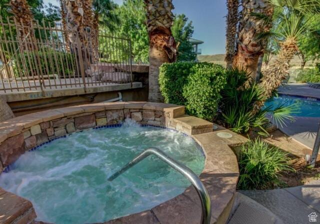 view of pool with a hot tub